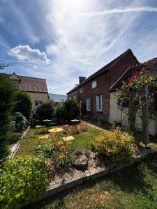 a yard with a table and chairs and a house at Au Nid du MONT in Le Mont-Saint-Adrien