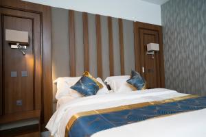 a bedroom with a large bed with blue and white pillows at Oxvera Hotel Limited in Umuahia +2 photos