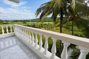 a balcony with a white railing and palm trees at Hotel Not Dot in north GOA in Calangute
