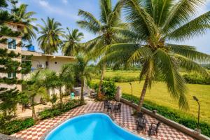 an aerial view of a resort with a swimming pool and palm trees at Hotel Not Dot in north GOA in Calangute