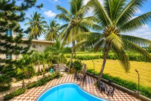a resort with a swimming pool and palm trees at Hotel Not Dot in north GOA in Calangute +13 photos