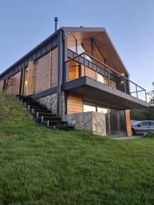 a house on top of a grassy hill at Vamas Villa in Dobroselica