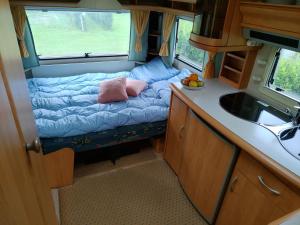 a small room with a bed and a sink at Nissum Fjord Camping in Fjand Gårde