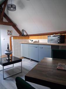 a kitchen with a counter top and a microwave at Chez Cosette, studio in Montreuil-sur-Mer
