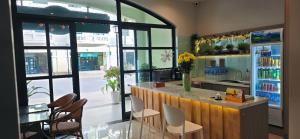 a restaurant with a counter with chairs and a refrigerator at HADU Hotel & Café Phu Quoc in Phú Quốc