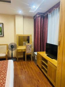 a hotel room with a bed and a television at Dragon Hotel Ha Noi in Hanoi