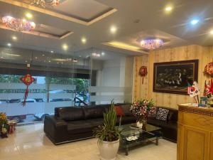 a living room with a leather couch and a glass table at Dragon Hotel Ha Noi in Hanoi