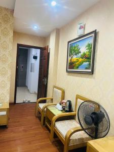 a living room with two chairs and a fan at Dragon Hotel Ha Noi in Hanoi