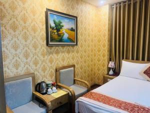 a hotel room with two beds and a picture on the wall at Dragon Hotel Ha Noi in Hanoi +42 photos