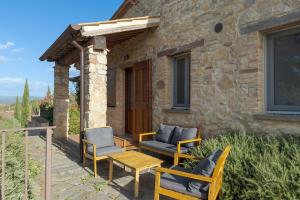 a patio with chairs and a table and a building at Peaceful Umbria views & heated infinity pool in Umbertide