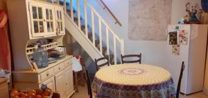 a kitchen with a table and a stair case at Une chambre en Amazonie in Le Menoux