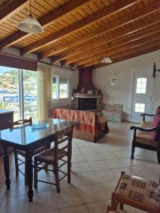a living room with a table and a fireplace at Nektaria on the Beach in Fournoi +42 photos