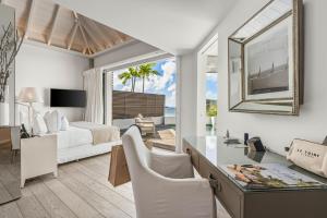 ein Schlafzimmer mit einem Bett und einem Schreibtisch mit Spiegel in der Unterkunft Le Toiny Hotel & Beach Club in Toiny
