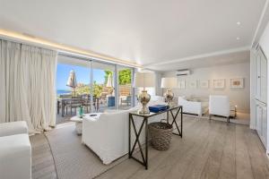 Ein Wohnzimmer mit weißen Möbeln und Meerblick in der Unterkunft Le Toiny Hotel & Beach Club in Toiny