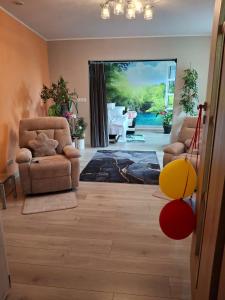a living room with two chairs and a sliding glass door at Kamienica Senator in Skierniewice