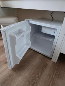 an empty white refrigerator with its door open at APARTAMENTI BrivdienuKolka in Kolka