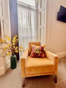 a chair with a pillow in front of a window at Scot Townhouse in Edinburgh