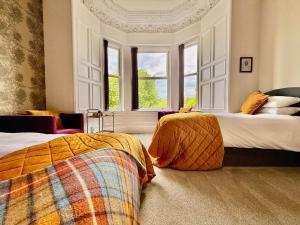 a bedroom with two beds and a window at Scot Townhouse in Edinburgh