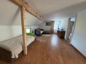 a bedroom with a bed and a living room at Butas Prie Marių in Juodkrantė