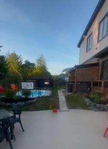 a backyard with a swimming pool and a house at La Spacieuse Riverstone CITQ3O1849 in Saint Pierre de Broughton