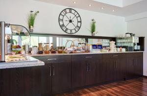 a kitchen with a large clock on the wall at Hotel am Gröbenbach in Gröbenzell