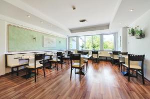 a dining room with tables and chairs and a chalkboard at Hotel am Gröbenbach in Gröbenzell