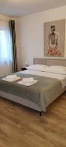 a bedroom with a large bed with towels on it at Apartmani Novosel in Šilo