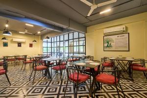 a dining room with tables and red chairs at Treebo Cultura in Hyderabad