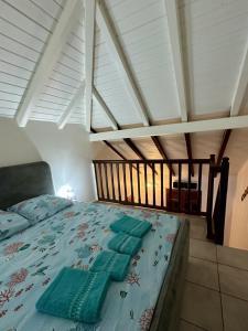 a bedroom with a bed with a blue comforter at Le Coeur des Iles in Sainte-Anne