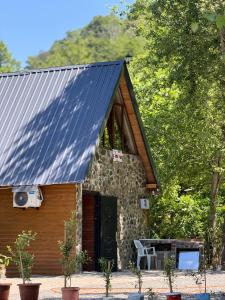 a stone cottage with a solar roof and a table at Guri's hut in Kirnat'i +15 photos