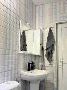 a white bathroom with a sink and a mirror at Guri's hut in Kirnat'i