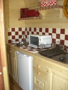 a kitchen with a counter with a toaster oven and a sink at Rêve de roulotte in Apt