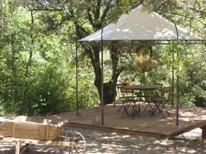 a wooden deck with a tent and a table at Rêve de roulotte in Apt