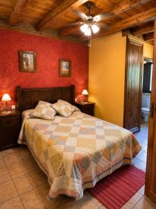 a bedroom with a bed and red walls at Posada La Vieja Escuela Valles Pasiegos in San Roque de Ríomiera