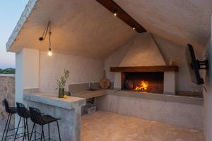 a kitchen with a fireplace with chairs and a stove at Villa Lapidea in Vodice
