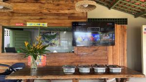 a wooden wall with a table with a tv on it at Pousada Parque dos Coqueiros in Piaçabuçu