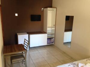 a small kitchen with a table and a refrigerator at M & S Hotel in Bauru