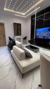 a living room with a couch and a flat screen tv at Greenwich Garden in Onisigun