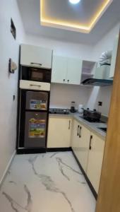 a small kitchen with a black and white refrigerator at Greenwich Garden in Onisigun +13 photos