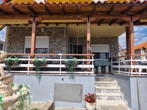 a house with a porch with potted plants on it at Apartment sofia sea view in Nea Vrasna