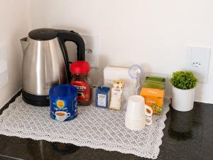 a kitchen counter with a coffee pot and other items at Atins Suites in Atins