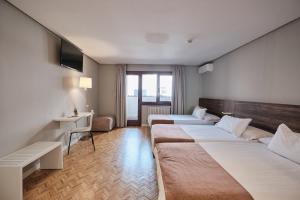 a hotel room with two beds and a television at Hotel Mogay in Chantada +36 photos