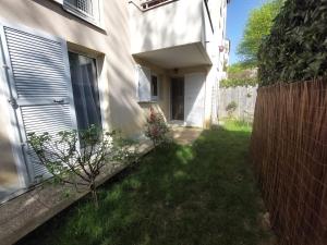 a small yard next to a house with a fence at Chambre privée avec Jardin in Les Ulis