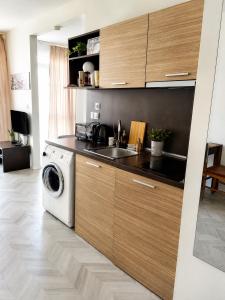 a kitchen with a washing machine and a sink at Bellissima Studio Sarafovo е вашият уютен дом само на 3 минути от плажа in Burgas +2 photos