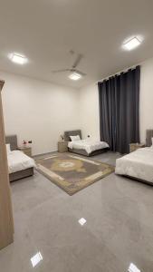 a room with two beds and a rug on the floor at منزل لافيدا La Vida Home in Salalah