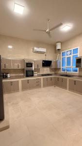 a large kitchen with white cabinets and a ceiling at منزل لافيدا La Vida Home in Salalah