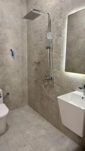 a bathroom with a shower and a toilet and a sink at منزل لافيدا La Vida Home in Salalah +17 photos