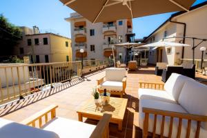 a balcony with couches and tables and umbrellas at Residence Dei Due Porti in Sanremo