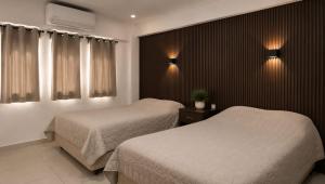 a hotel room with two beds and two lights at Hotel Siesta Escamela in Ixtaczoquitlán