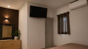 a bedroom with a flat screen tv on the wall at Hotel Siesta Escamela in Ixtaczoquitlán